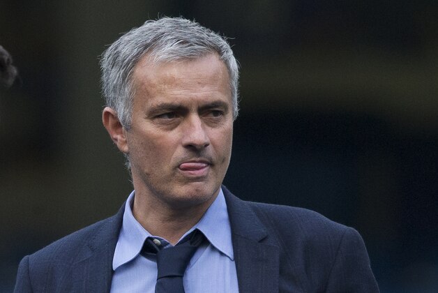Chelsea's head coach Jose Mourinho talks with his coaching staff after coming back out onto the pitch after the English Premier League soccer match between Chelsea and Liverpool at Stamford Bridge stadium in London, Saturday, Oct. 31, 2015.  Liverpool won the match 3-1.  (AP Photo/Matt Dunham)