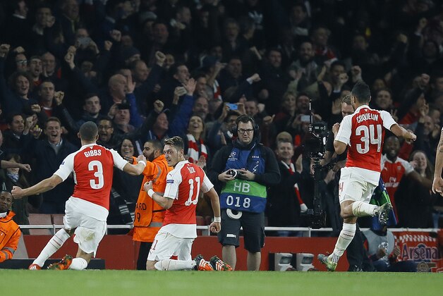 Arsenal's Mesut Ozil, second from left, celebrates with teammates after scoring during the Champions League Group F soccer match between Arsenal and Bayern Munich at Emirates stadium in London Tuesday, Oct. 20, 2015. (AP Photo/Kirsty Wigglesworth)