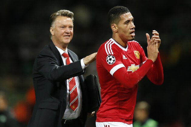 Manchester United manager Louis van Gaal, left, congratulates scorer of the winning goal Chris Smalling after the Champions League Group B soccer match between Manchester United and VfL Wolfsburg at Old Trafford Stadium in Manchester, England, Wednesday, Sept. 30, 2015. (AP Photo/Jon Super)