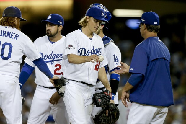 Los Angeles Dodgers starting pitcher Zack Greinke hands the ball to manager Don Mattingly, right, as he leaves the game during the seventh inning in Game 5 of baseball's National League Division Series against the New York Mets Thursday, Oct. 15, 2015, in Los Angeles. (AP Photo/Alex Gallardo)