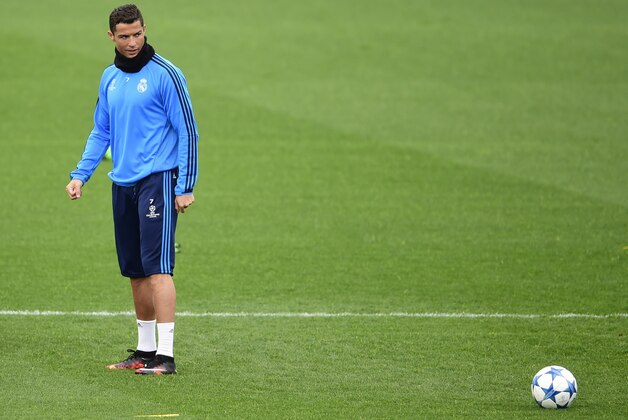 Real Madrid's Portuguese forward Cristiano Ronaldo looks at the ball during a training session at Valdebebas sport city in Madrid on November 2, 2015 on the eve of their Champions' League football match against Paris Saint Germain. AFP PHOTO/ PIERRE-PHILIPPE MARCOU        (Photo credit should read PIERRE-PHILIPPE MARCOU/AFP/Getty Images)