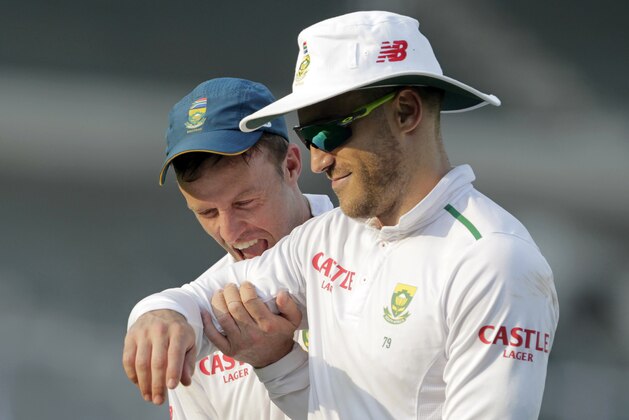 South African cricketer AB de Villiers  playfully bites teammate Faf du Plessis after a practice match against Indian Board President's XI in Mumbai, India, Saturday, Oct. 31, 2015. De Villiers notched a timely century Saturday in the South Africans' drawn tour game against an Indian Board President's XI. (AP Photo/Rajanish Kakade)