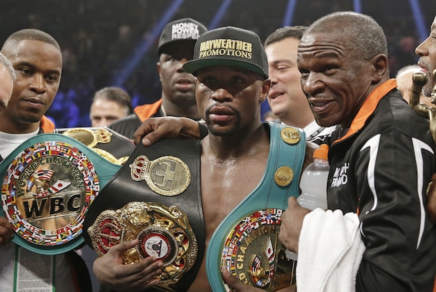 Floyd Mayweather Jr., left, poses with his champion's belts and his father, head trainer Floyd Mayweather Sr., after his victory over Manny Pacquiao, from the Philippines,  in their welterweight title fight on Saturday, May 2, 2015 in Las Vegas. (AP Photo/Isaac Brekken)