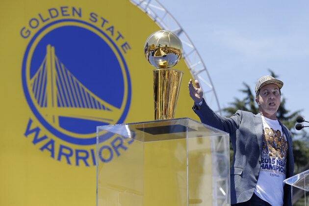 Golden State Warriors owner Joe Lacob gestures while speaking next to the Larry O'Brien Championship Trophy during a rally for winning the NBA basketball championship in Oakland, Calif., Friday, June 19, 2015. (AP Photo/Jeff Chiu)