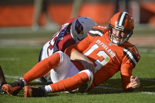 This Sunday, Nov. 1, 2015, photo shows Cleveland Browns quarterback Josh McCown getting up slowly after getting tackled by Arizona Cardinals defensive end Frostee Rucker in an NFL football game, in Cleveland.  Browns coach Mike Pettine says McCown is sore and it's not yet known if he'll play Thursday in Cincinnati. McCown injured his ribs in the second half of Sunday's loss to Arizona. Pettine would not disclose the results of X-rays taken on McCown, who has taken a pounding in recent weeks. (AP Photo/David Richard)
