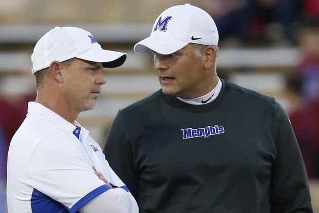 Tulsa head coach Phillip Montgomery, left, talks with Memphis head coach Justin Fuente, right before the start of an NCAA college football game in Tulsa, Okla., Friday, Oct. 23, 2015. (AP Photo/Sue Ogrocki)