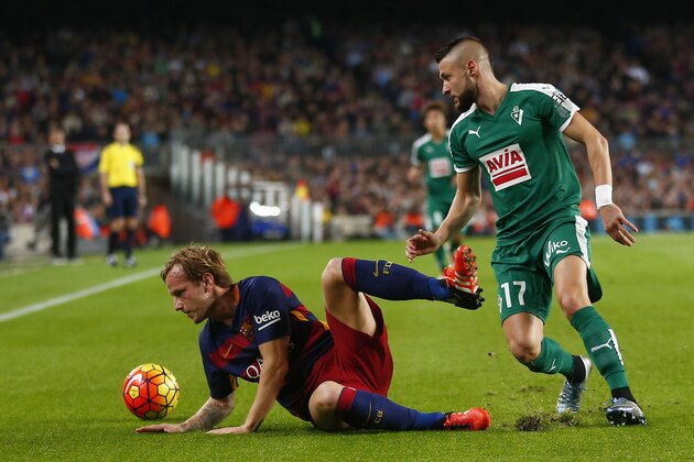 FC Barcelona's Ivan Rakitic, left, duels for the ball against Eibar's Junca during a Spanish La Liga soccer match at the Camp Nou stadium in Barcelona, Spain, Sunday, Oct. 25, 2015. (AP Photo/Manu Fernandez)