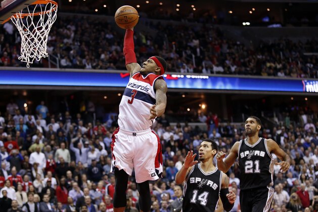 Washington Wizards guard Bradley Beal goes in for a dunk in front of San Antonio Spurs guard Danny Green (14) and center Tim Duncan (21) during the second half of an NBA basketball game, Wednesday, Nov. 4, 2015, in Washington. The Wizards won 102-99. (AP Photo/Alex Brandon)