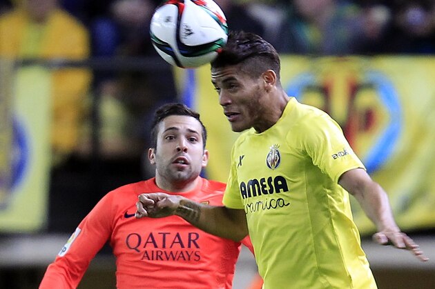 Barcelona's Jordi Alba, left,  duels for the ball with Villarreal's Jonathan dos Santos from Mexico, during the semifinal, second leg, Copa del Rey soccer match between FC Barcelona and Villarreal at the Madrigal stadium in Villarreal, Spain, Wednesday, March 4, 2015. (AP Photo/Alberto Saiz)