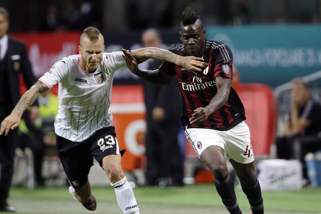 AC Milan's Mario Balotelli, right, challenges for the ball with Palermo's Aljaz Struna during the Serie A soccer match between AC Milan and Palermo at the San Siro stadium in Milan, Italy, Saturday, Sept. 19, 2015. AC Milan beat Palermo 3-2 for only its second win of the season as the visiting side missed the chance to move provisionally top of Serie A on Saturday. (AP Photo/Antonio Calanni)