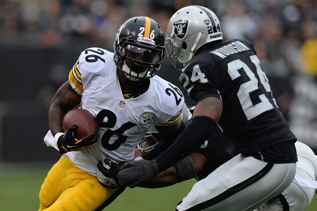 OAKLAND, CA - OCTOBER 27:  Le'Veon Bell #26 of the Pittsburgh Steelers carries gets tackled by Charles Woodson #24 the Oakland Raiders during the third quarter at O.co Coliseum on October 27, 2013 in Oakland, California.  (Photo by Thearon W. Henderson/Getty Images)