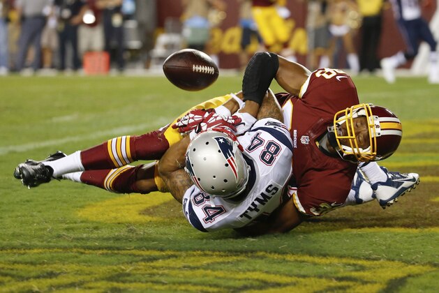 New England Patriots wide receiver Brian Tyms loses control of the ball in the end zone on a hit from Washington Redskins defensive back Chase Minnifield during the second half of an NFL football preseason game in Landover, Md., Thursday, Aug. 7, 2014. (AP Photo/Alex Brandon)