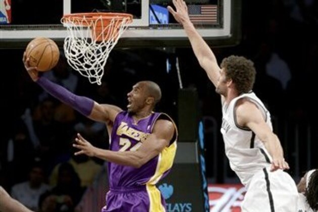 Los Angeles Lakers' Kobe Bryant, left, puts up a shot underneath the basket while Brooklyn Nets' Brook Lopez defends during the first half of the NBA basketball game at the Barclays Center Tuesday, Feb. 5, 2013 in New York. (AP Photo/Seth Wenig)