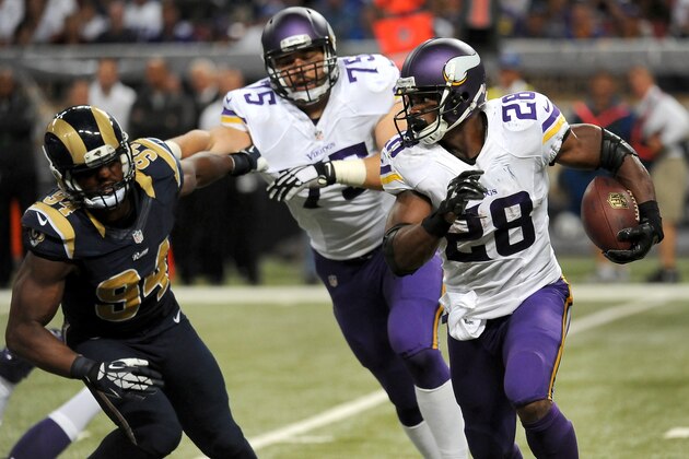 El running back Adrian Peterson (derecha) de los Viking de Minnesota avanza con el bal?n ante los Rams de San Luis el domingo 7 de septiembre de 2014. (AP Foto/L.G. Patterson)