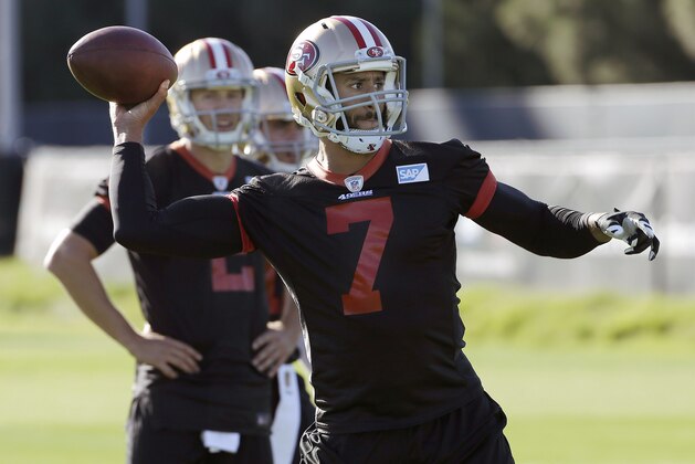 San Francisco 49ers quarterback Blaine Gabbert, rear, watches as quarterback Colin Kaepernick (7) passes during an NFL football practice in Santa Clara, Calif., Wednesday, Nov. 4, 2015. Head coach Jim Tomsula announced that the 49ers have officially made the change at quarterback from Kaepernick to Gabbert. (AP Photo/Jeff Chiu)