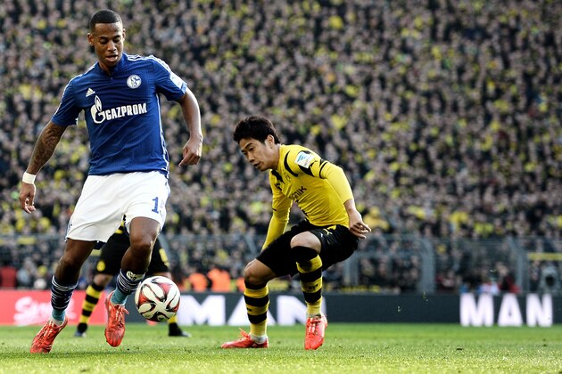 DORTMUND, GERMANY - FEBRUARY 28:  Dennis Aogo (L) of Schalke vies with Shinji Kagawa (R) of Dortmund during the Bundesliga match between Borussia Dortmund and FC Schalke 04 at Signal Iduna Park on February 28, 2015 in Dortmund, Germany.  (Photo by Sascha Steinbach/Getty Images for MAN)