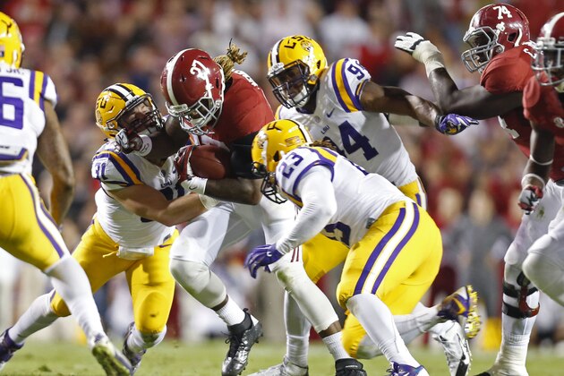 Alabama running back Derrick Henry (27) is tackled by LSU linebacker D.J. Welter (31)and linebacker Lamar Louis (23) in the first half of an NCAA college football game in Baton Rouge, La., Saturday, Nov. 8, 2014. (AP Photo/Jonathan Bachman)