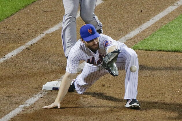 New York Mets first baseman Daniel Murphy, right, stretches for the ball thrown wide of the bag as Colorado Rockies' Nolan Arenado sprints down the first base line during the fourth inning of a baseball game, Tuesday, Aug. 11, 2015, in New York. Arenado was called out on the play, which was overturned after a challenge, in which Murphy was ruled to have pulled his foot off the bag. (AP Photo/Julie Jacobson)