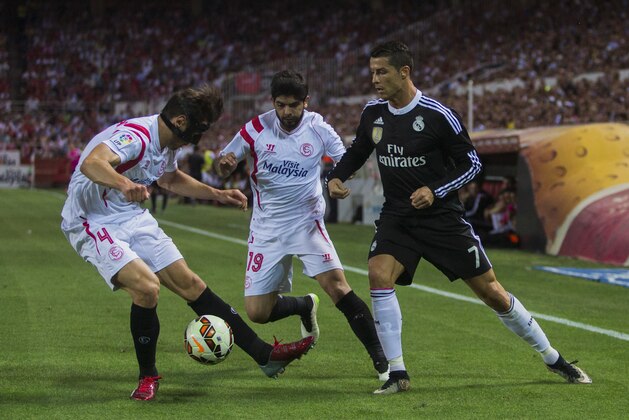 Real Madrid's Cristiano Ronaldo, right, in action with Sevilla’s Grzegorz Krychowiak, left, and Sevilla’s Ever Banega, centre, during a Spanish La Liga soccer match between Sevilla and Real Madrid at the Ramon Sanchez Pizjuan stadium in Sevilla, Spain, Saturday, May 2, 2015. (AP Photo/Andres Kudacki)