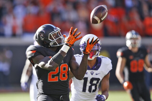 Oklahoma State wide receiver James Washington (28) catches a pass in front of TCU safety Nick Orr (18) and carries it in for a touchdown in the first quarter of an NCAA college football game in Stillwater, Okla., Saturday, Nov. 7, 2015. (AP Photo/Sue Ogrocki)