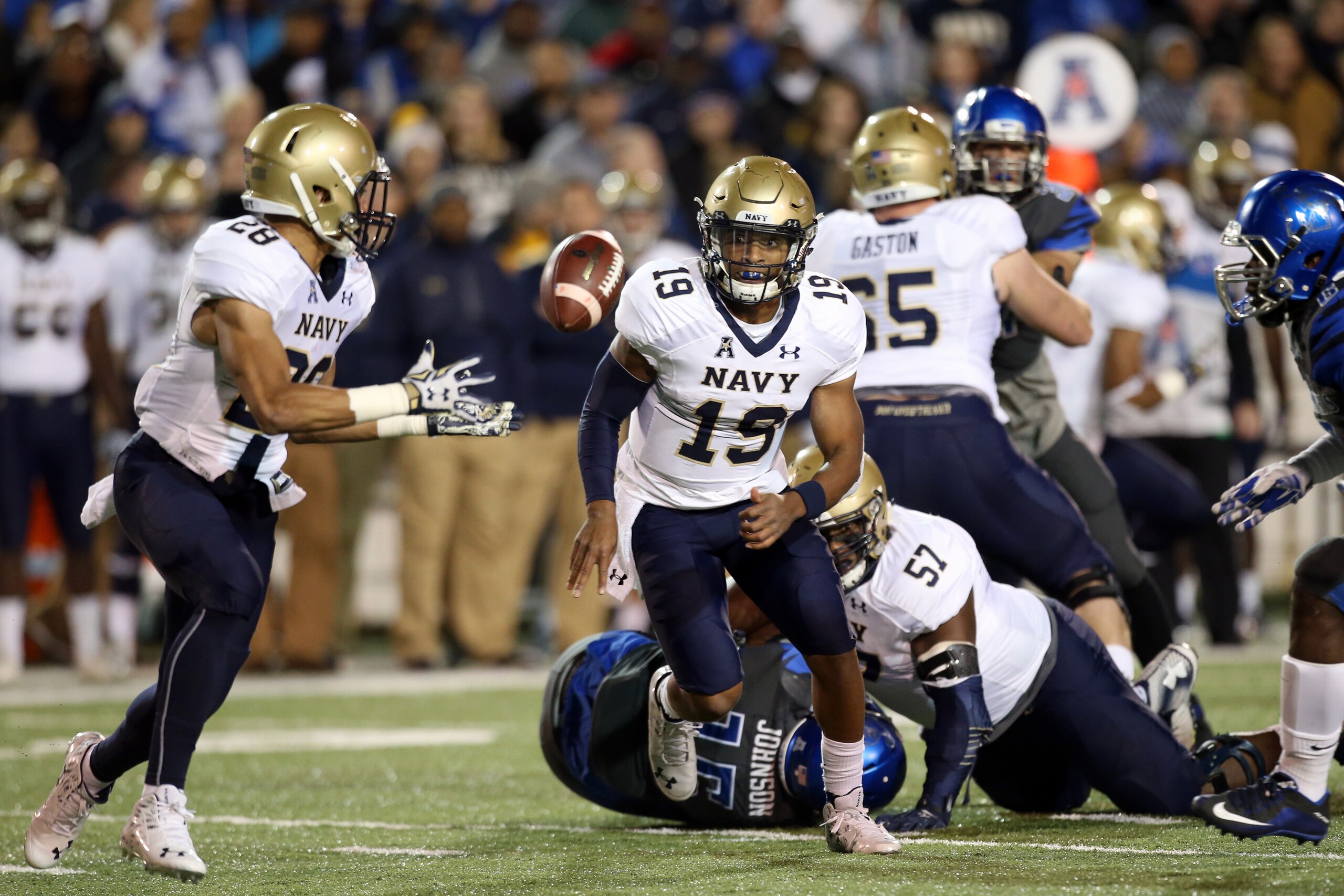 MEMPHIS, TN - NOVEMBER 7: Keenan Reynolds #19 of the Navy Midshipmen laterals the ball to Dishan Romine #28 of the Navy Midshipmen against the Memphis Tigers on November 7, 2015 at Liberty Bowl Memorial Stadium in Memphis, Tennessee. (Photo by Joe Murphy/Getty Images)