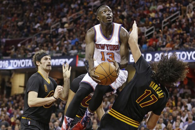 New York Knicks' Jerian Grant, center, drives to the basket against Kevin Love, left, and Anderson Varejao, from Brazil, during the first half of an NBA basketball game Wednesday, Nov. 4, 2015, in Cleveland. (AP Photo/Tony Dejak)