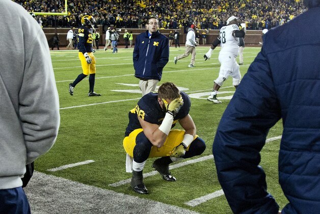 Michigan tight end Jake Butt, bottom, reacts after losing 27-23 to Michigan State in an NCAA college football gamein Ann Arbor, Mich., Saturday, Oct. 17, 2015.  (AP Photo/Tony Ding)