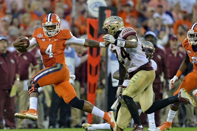 Clemson quarterback Deshaun Watson (4) fends off Florida State's Terrance Smith to gain a first down during the first half of an NCAA college football game Saturday, Nov. 7, 2015,  in Clemson,  S.C.  (AP Photo/Richard Shiro)