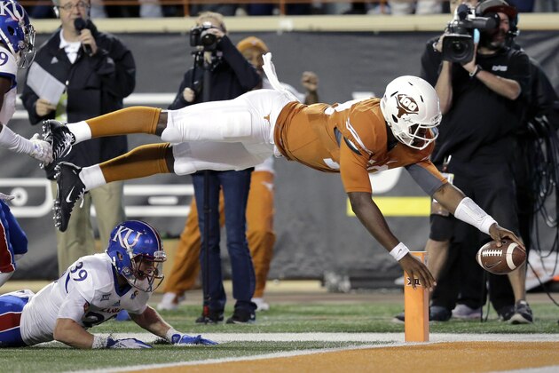 Texas quarterback Tyrone Swoopes, right, dives for a touchdown as Kansas defendersTyrone Miller Jr. (19) and Michael Glatczak (39) pursue during the second half of an NCAA college football game, Saturday, Nov. 7, 2015, in Austin, Texas. (AP Photo/Eric Gay)