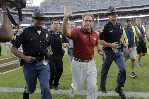 Alabama head coach Nick Saban, center, waves to fans as he runs off the field following an NCAA college football game, Saturday, Oct. 17, 2015, in College Station, Texas. Alabama won 41-23. (AP Photo/Eric Gay)
