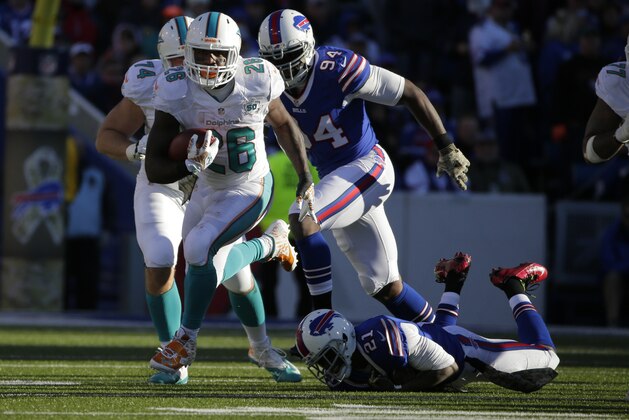 Miami Dolphins running back Lamar Miller (26) breaks a tackle by =tb21n= during the second half of an NFL football game Sunday, Nov. 8, 2015, in Orchard Park, N.Y. (AP Photo/Bill Wippert)