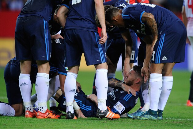 SEVILLE, SPAIN - NOVEMBER 08:  Real Madrid players gather around their captain Sergio Ramos after he injured his shoulder while scoring his team's opening goal during the La Liga match between Sevilla FC and Real Madrid CF at Estadio Ramon Sanchez Pizjuan on November 8, 2015 in Seville, Spain.  (Photo by Denis Doyle/Getty Images)