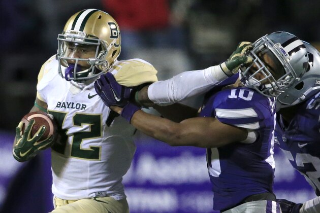 Baylor running back Shock Linwood (32) stiff-arms Kansas State defensive back Donnie Starks (10) during the second half of an NCAA college football game in Manhattan, Kan., Thursday, Nov. 5, 2015. Baylor defeated Kansas State 31-24. (AP Photo/Orlin Wagner)
