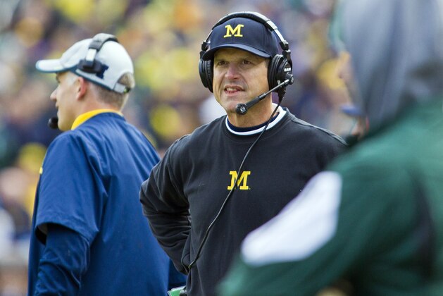 Michigan head coach Jim Harbaugh, wearing a headset, reacts on the sideline in the first quarter of an NCAA college football game against Michigan State in Ann Arbor, Mich., Saturday, Oct. 17, 2015. (AP Photo/Tony Ding)