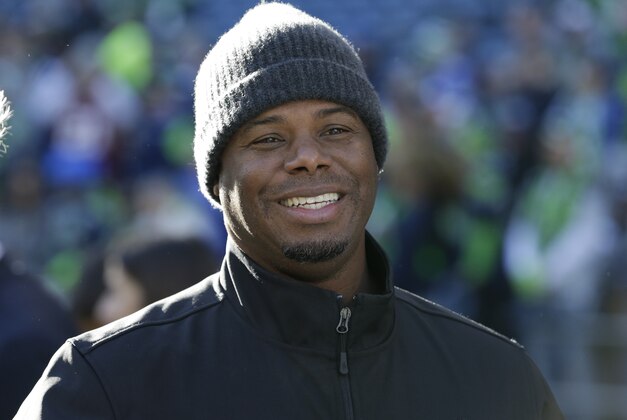 Former Seattle Mariners' Ken Griffey Jr. smiles as he stands on the sidelines before an NFL football game between the Seattle Seahawks and San Francisco 49ers, Sunday, Dec. 14, 2014, in Seattle. (AP Photo/Elaine Thompson)