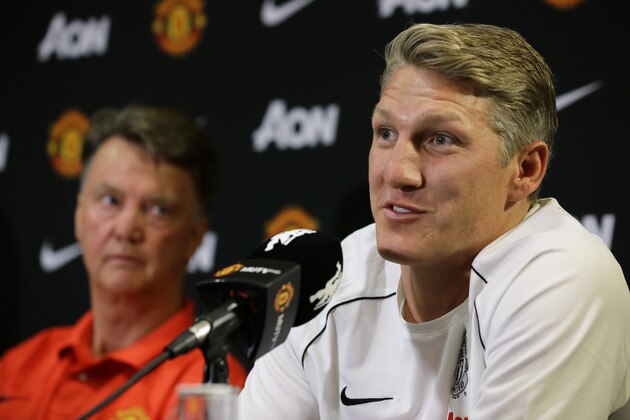 Manchester United manager Louis van Gaal, left, looks on as new signing Bastian Schweinsteiger speaks during a press conference, Wednesday, July 15, 2015, in Bellevue, Wash. Manchester United is in Seattle for an international friendly soccer match against Mexico's Club America to be played on Friday. (AP Photo/Ted S. Warren)