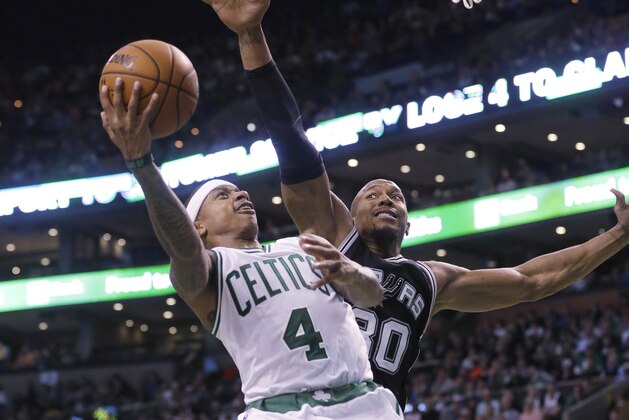 Boston Celtics guard Isaiah Thomas, left, takes a shot at the basket as San Antonio Spurs forward David West, right, tries to block him in the third quarter of an NBA basketball game, Sunday, Nov. 1, 2015, in Boston. The Spurs won 95-87. (AP Photo/Steven Senne)