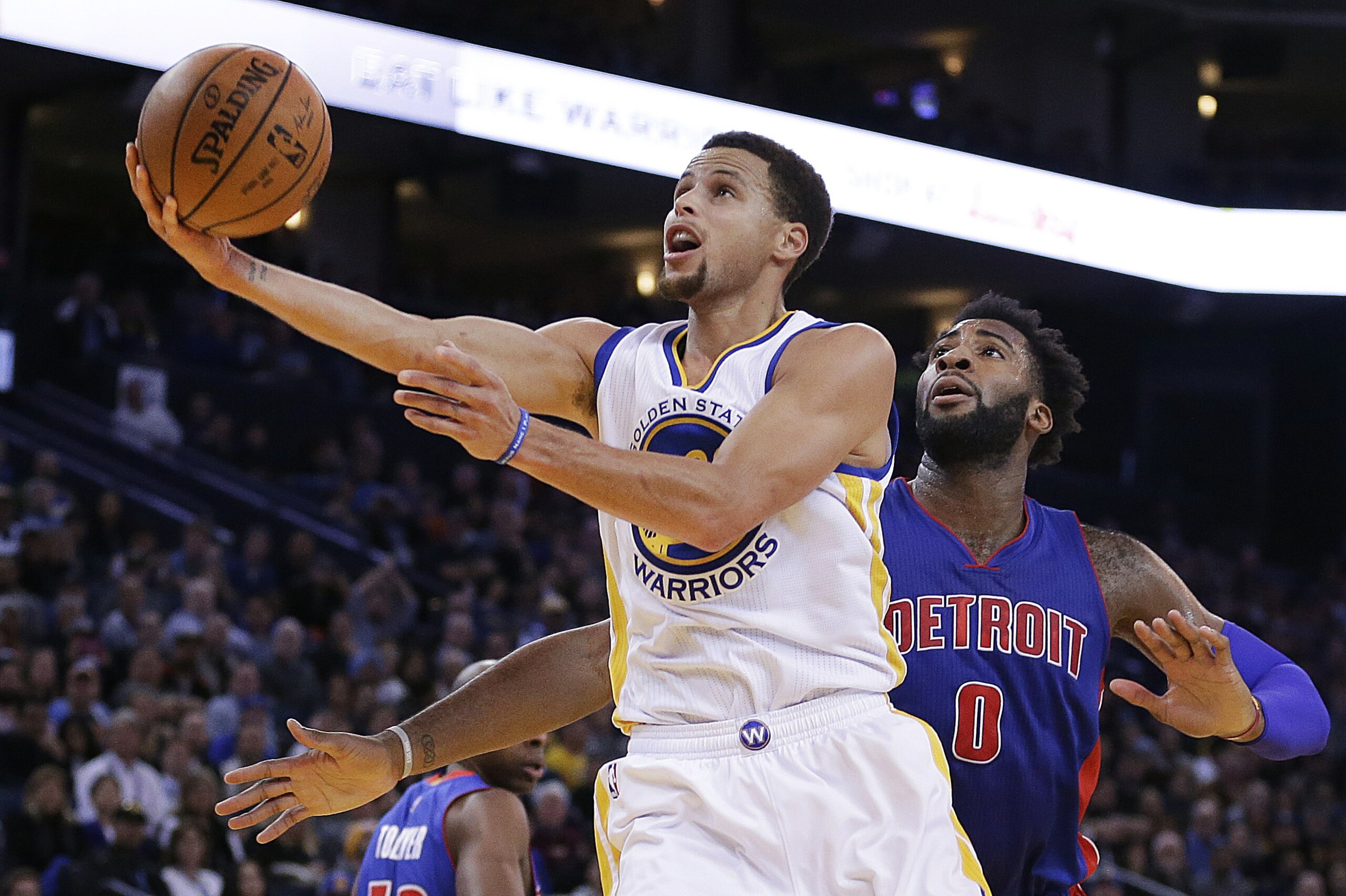 Golden State Warriors' Stephen Curry, left, lays up a shot past Detroit Pistons' Andre Drummond (0) during the second half of an NBA basketball game Monday, Nov. 9, 2015, in Oakland, Calif. The Warriors won 109-95. (AP Photo/Ben Margot)
