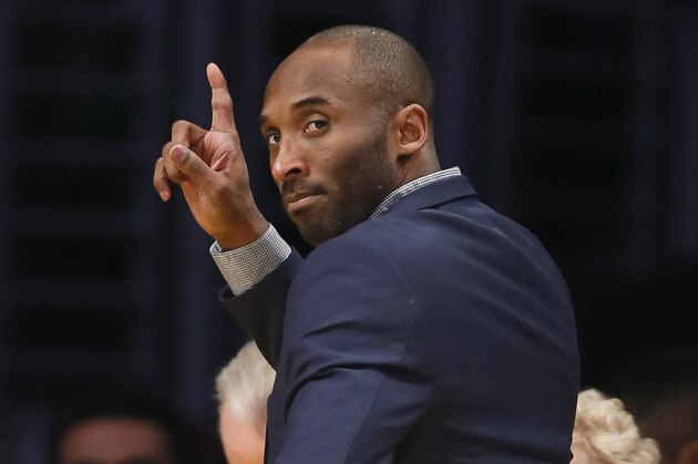 Los Angeles Lakers' Kobe Bryant waves to Detroit Pistons' Jodie Meeks as he leaves the court after an NBA basketball game, Tuesday, March 10, 2015, in Los Angeles. The Lakers won 93-85. (AP Photo/Danny Moloshok)
