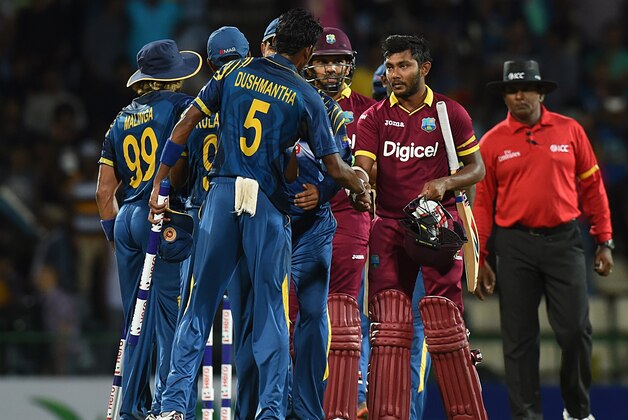 Sri Lanka's team is congratulated by West Indies Cricketer Devendra Bishoo (R) after Sri Lanka's victory during the first T20 International cricket match between Sri Lanka and the West Indies at the Pallekele International Cricket Stadium in Pallekele on November 9, 2015. AFP PHOTO/ ISHARA S KODIKARA        (Photo credit should read Ishara S.KODIKARA/AFP/Getty Images)