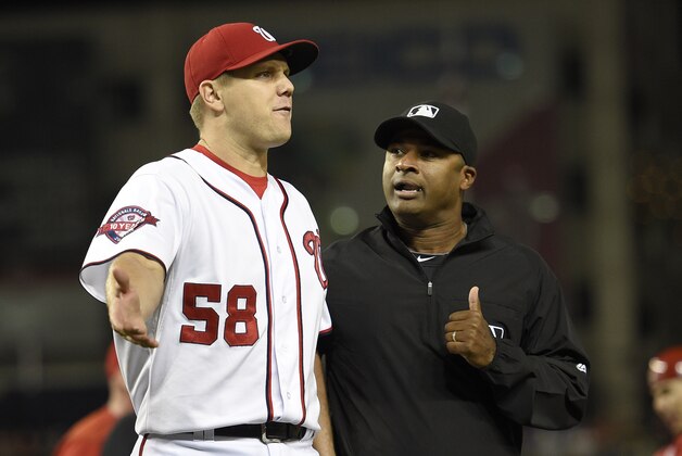 Washington Nationals relief pitcher Jonathan Papelbon (58) reacts next to second base umpire Alan Porter, right, during the ninth inning of an interleague baseball game, Wednesday, Sept. 23, 2015, in Washington. Papelbon was ejected for hitting Baltimore Orioles' Manny Machado with a pitch. The Orioles won 4-3. (AP Photo/Nick Wass)