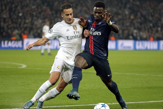 PSG's Serge Aurier, right, challenges for the ball with Real Madrid's Lucas Vazquez during the Champions League group A soccer match between Paris St Germain and Real Madrid at the Parc des Princes stadium in Paris, Wednesday, Oct. 21, 2015. (AP Photo/Thibault Camus)