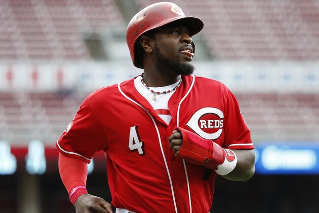 Cincinnati Reds' Brandon Phillips runs back to the dugout after being tagged out by Chicago Cubs second baseman Addison Russell when he slipped a lead toward home in the sixth inning of a baseball game, Thursday, Oct. 1, 2015, in Cincinnati. The Cubs won 5-3. (AP Photo/John Minchillo)