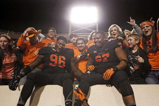 STILLWATER, OK - NOVEMBER 7 : Defensive tackle Vincent Taylor #96 and defensive tackle Eric Davis #97 of the Oklahoma State Cowboys celebrate with the fans in the stands after the game against the TCU Horned Frogs November 7, 2015 at Boone Pickens Stadium in Stillwater, Oklahoma. The Cowboys defeated the Horned Frogs 49-29. (Photo by Brett Deering/Getty Images)