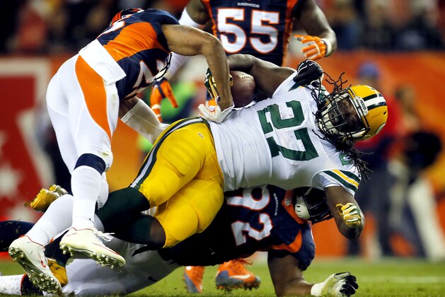 Green Bay Packers running back Eddie Lacy (27) is hit by Denver Broncos nose tackle Sylvester Williams (92) and cornerback Chris Harris (25) during the second half of an NFL football game, Sunday, Nov. 1, 2015, in Denver. (AP Photo/Joe Mahoney)