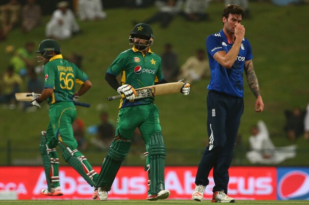 Pakistan's Muhammad Hafeez (C) and Babar Azam (L) run between wickets as England's cricketer Reece Topley (R) reacts during the first One Day International (ODI) match between Pakistan and England at the Zayed Cricket Stadium in the Gulf Emirate of Abu Dhabi on November 11, 2015. AFP PHOTO / MARWAN NAAMANI        (Photo credit should read MARWAN NAAMANI/AFP/Getty Images)