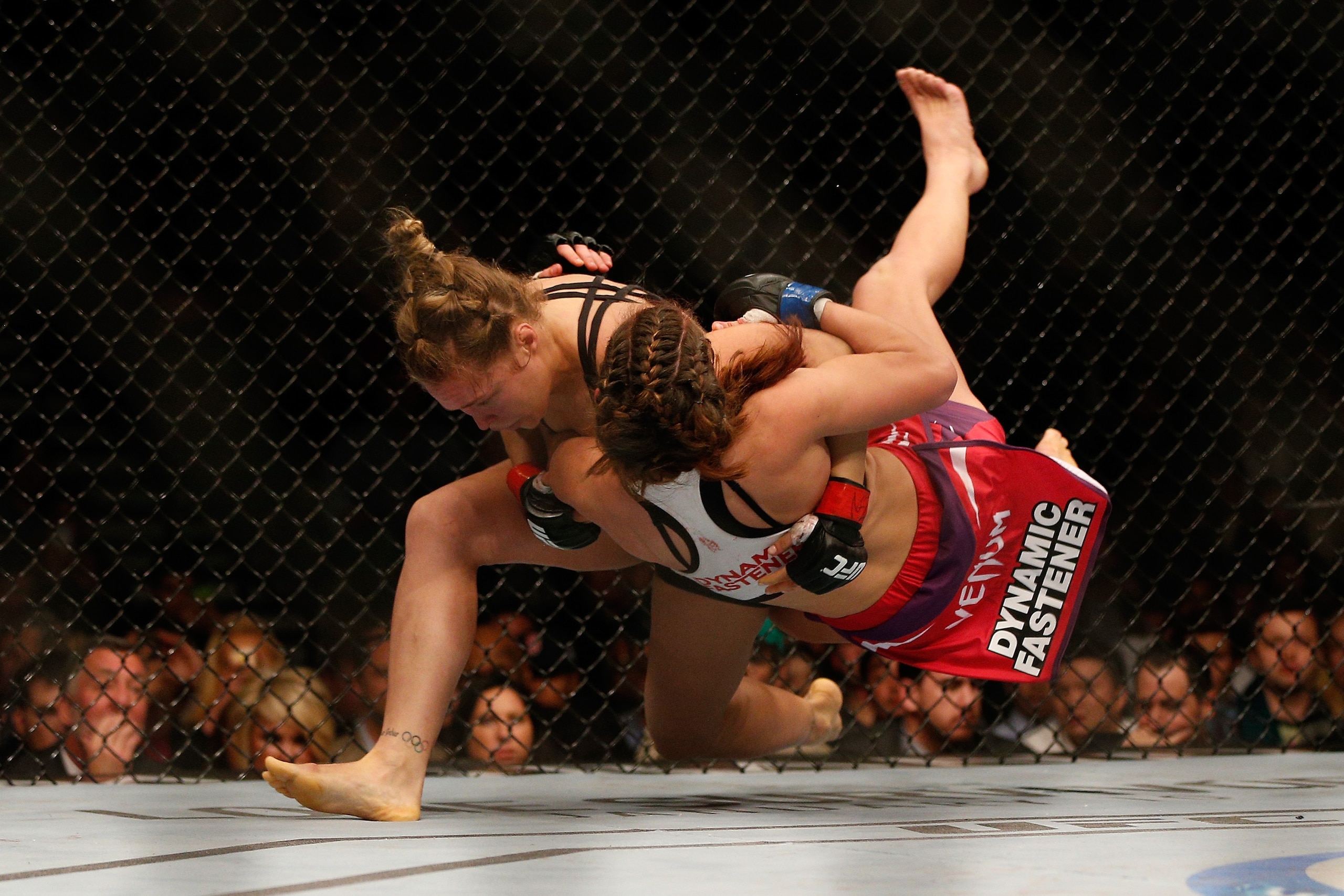 LAS VEGAS, NV - DECEMBER 28:  (L-R) Ronda Rousey throws Miesha Tate in their UFC women's bantamweight championship bout during the UFC 168 event at the MGM Grand Garden Arena on December 28, 2013 in Las Vegas, Nevada. (Photo by Josh Hedges/Zuffa LLC/Zuffa LLC via Getty Images)