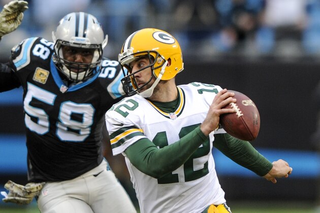 Green Bay Packers quarterback Aaron Rodgers (12) scrambles as Carolina Panthers outside linebacker Thomas Davis (58)  defends during a NFL football game in Charlotte, NC, Sunday, Nov. 9, 2015. (AP Photo/Mike McCarn)
