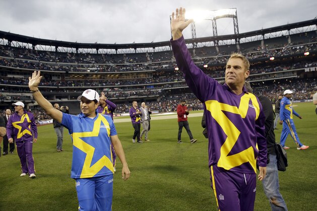 Sachin Tendulkar, left, and Shane Warne waves at fans as they take a lap around the field after the first game of the Cricket All-Stars series games, Saturday, Nov. 7, 2015, at Citi Field in New York. The three-game series will be played in Major League Baseball stadiums in New York, Houston and Los Angeles. Warne's Warriors beat Sahchin's Blasters 141-140. (AP Photo/Mary Altaffer)