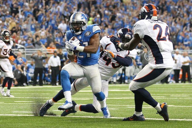DETROIT, MI - SEPTEMBER 27: Ameer Abdullah #21 of the Detroit Lions scores a third quarter touchdown while being defended by the Denver Broncos at Ford Field on September 27, 2014 in Detroit, Michigan. (Photo by Leon Halip/Getty Images)
